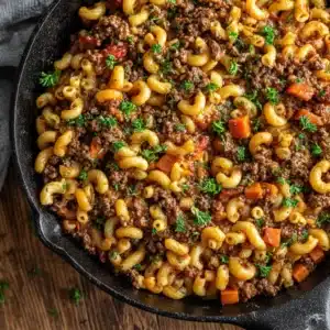 The ingredients for making American goulash laid out, including ground beef, macaroni, onions, and canned tomatoes.