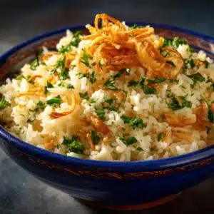An extreme close-up shot of fluffy butter rice with deeply caramelized onions mixed in, showing the texture of individual grains.