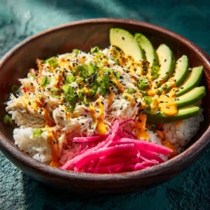 A close-up shot of a deconstructed sushi bowl filled with seasoned rice, spicy kanikama crab salad, and fresh avocado.