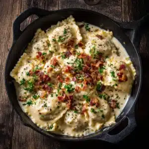 A beautiful serving of creamy ravioli carbonara in a rustic bowl, showcasing the silky egg-based sauce and crispy pancetta.