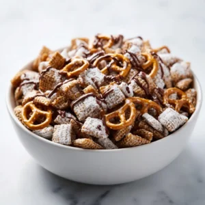 A top-down macro shot of the Salted Caramel Pretzel Puppy Chow ingredients before mixing, a key step in this sweet and salty snack mix recipe.