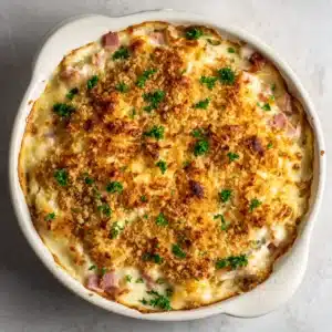 An overhead view of the Chicken Cordon Bleu Casserole, showing the combination of pasta, ham, and chicken in a creamy Dijon sauce before baking.