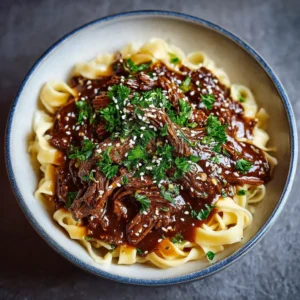 A close-up shot of the savory Korean beef sauce simmering in the slow cooker with tender, shredded beef. The rich, glossy sauce is bubbling around the meat.