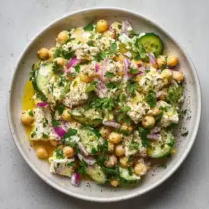 A bowl of healthy cottage cheese and chickpea salad with fresh herbs and crisp vegetables, ready for a delicious meal prep lunch.