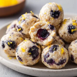 Fresh ingredients for Lemon Blueberry Protein Bites including blended cottage cheese, rolled oats, and deep purple blueberries.