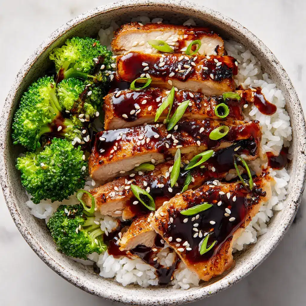 A complete Teriyaki Chicken Rice Bowl from above, showing the placement of the glazed chicken, fluffy rice, and bright green steamed broccoli florets in a textured ceramic bowl.