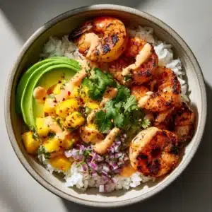 A close-up top-down view of a colorful Shrimp and Avocado Bowl, highlighting the perfectly charred shrimp and the creamy chili-lime drizzle. (Shrimp and Avocado Bowls)