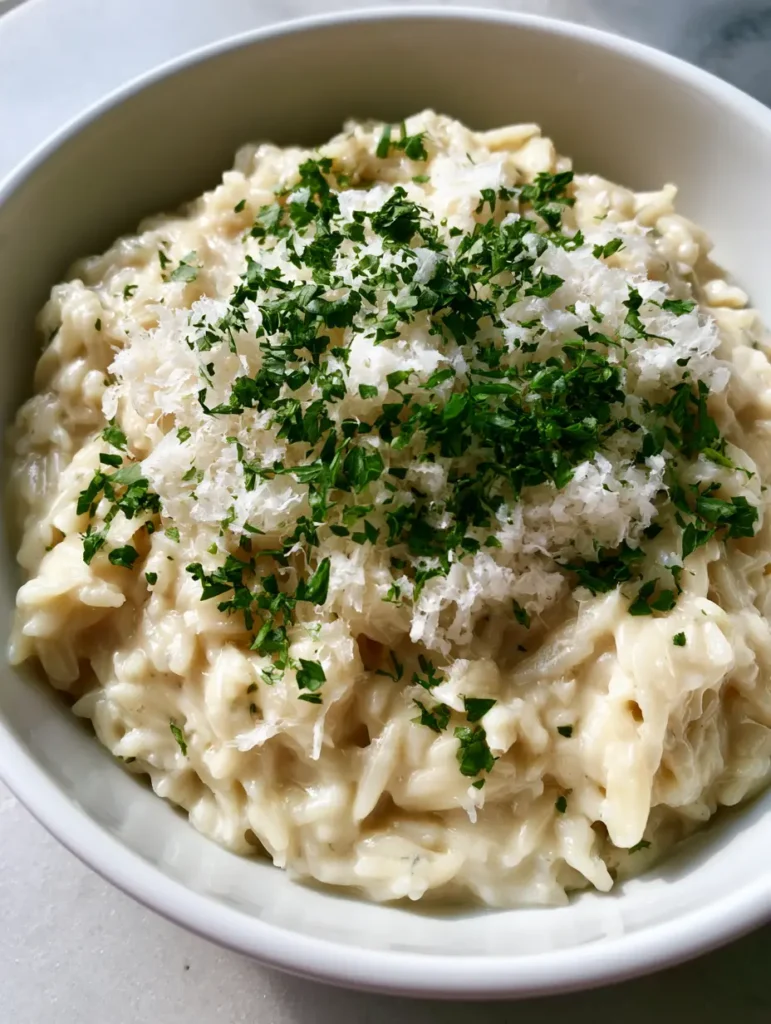 Close-up detail of Creamy Garlic Parmesan Orzo highlighting the fluffy grated parmesan and tender pasta grains.