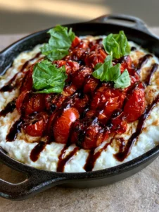Close-up of melted ricotta and mozzarella base with red blistered tomatoes for the Tomato Bruschetta Dip.
