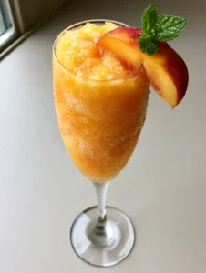Close-up of a Frozen Peach Bellini showing the slushy texture and fine peach pulp.