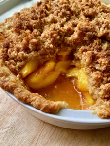 Close up of a Peach Pie Recipe showing the interior layers of yellow peaches and translucent amber syrup.